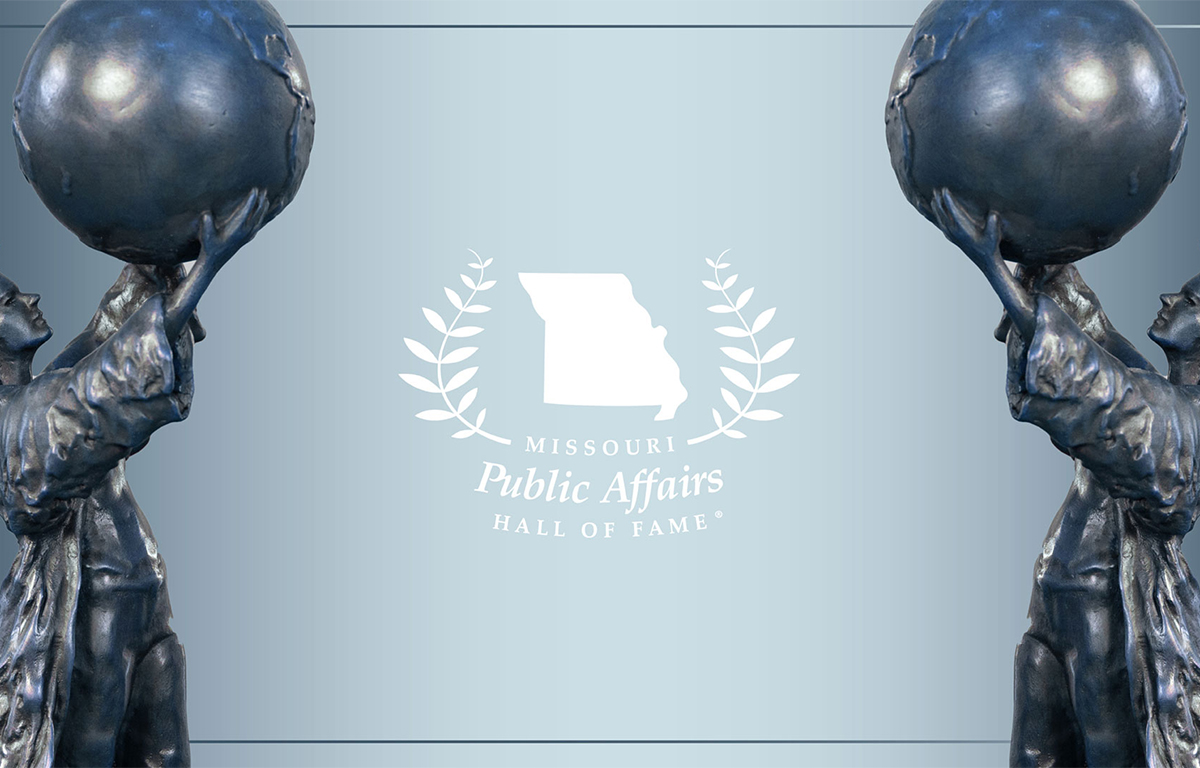 Evening view of Citizen Scholar statue backlit by Strong Hall.