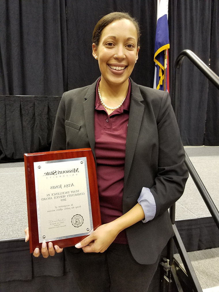 A’dja Jones holding her Staff Excellence in Community Service Award