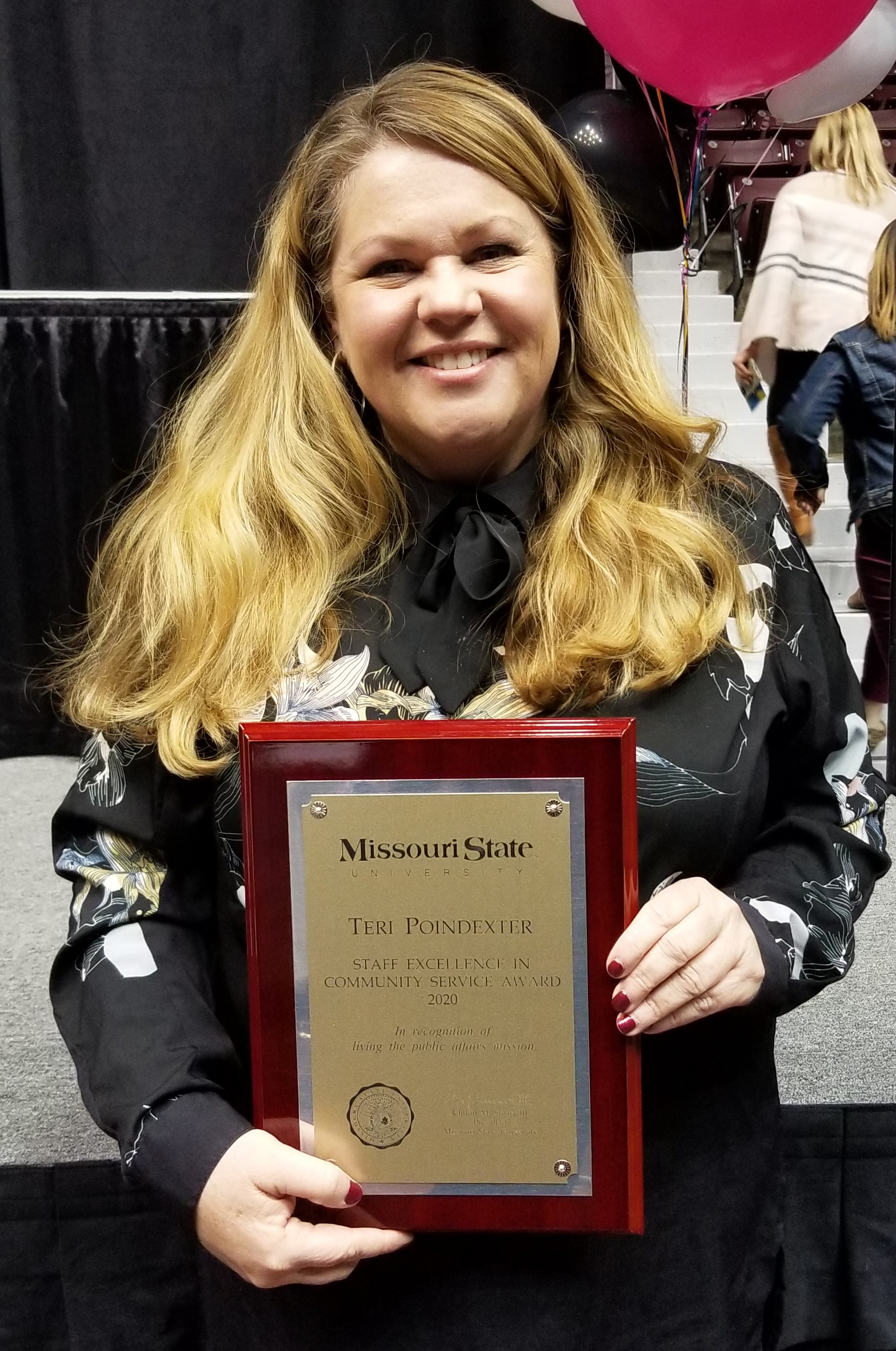 a picture of Teri Poindexter with plaque